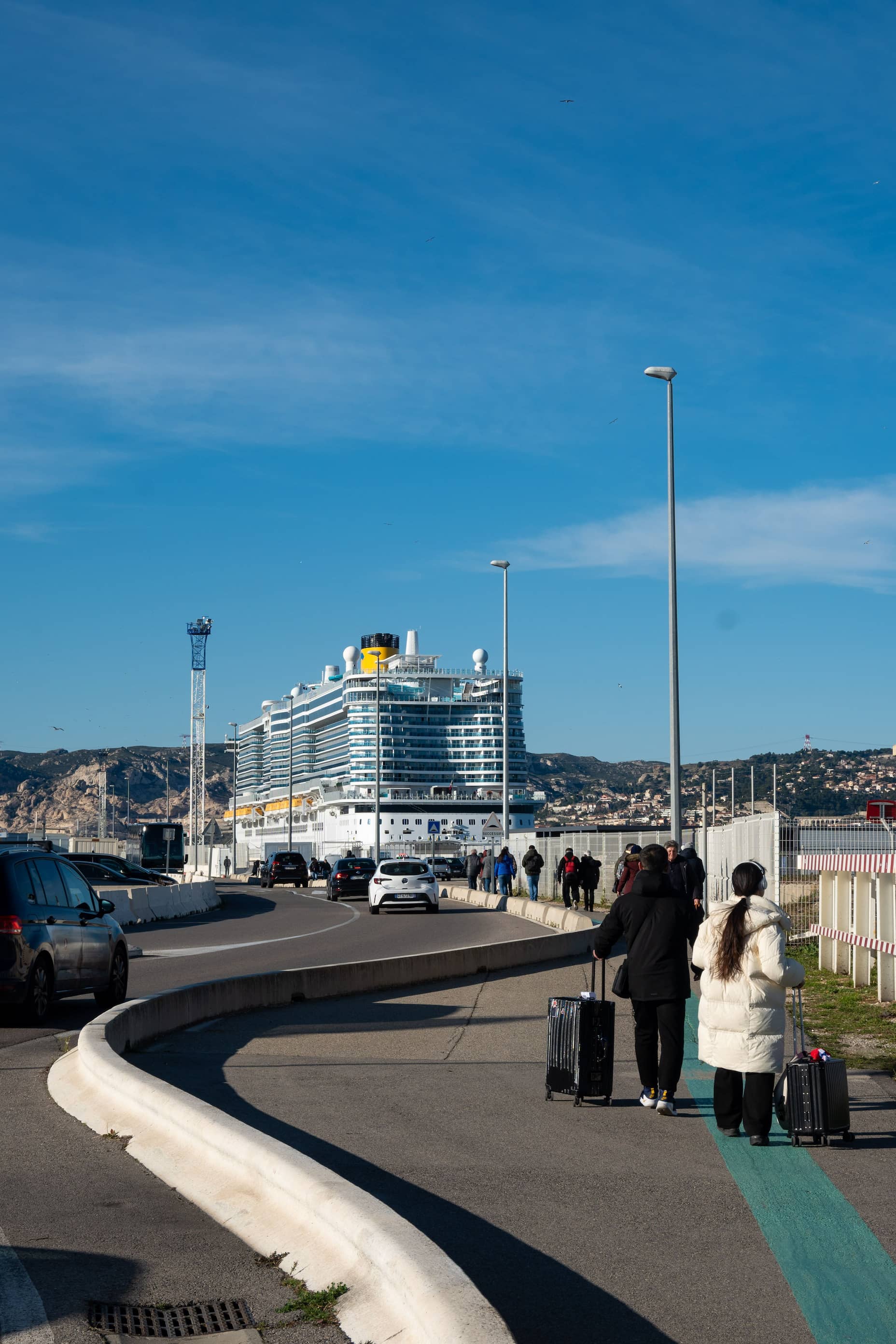 Pasajeros con maletas haciendo check-in en la terminal de cruceros
