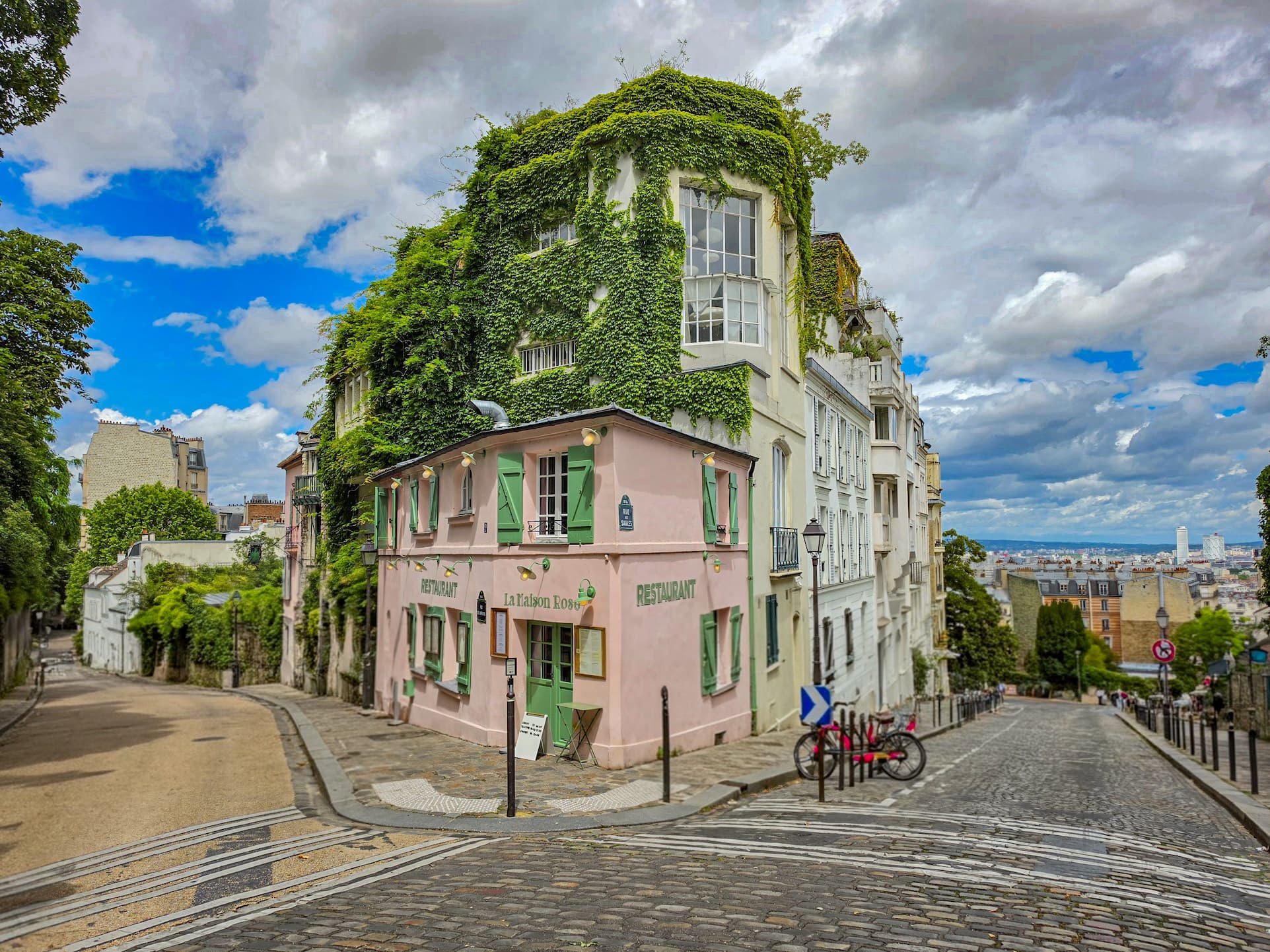 Calle empedrada de Montmartre al amanecer con el Sacré-Coeur al fondo