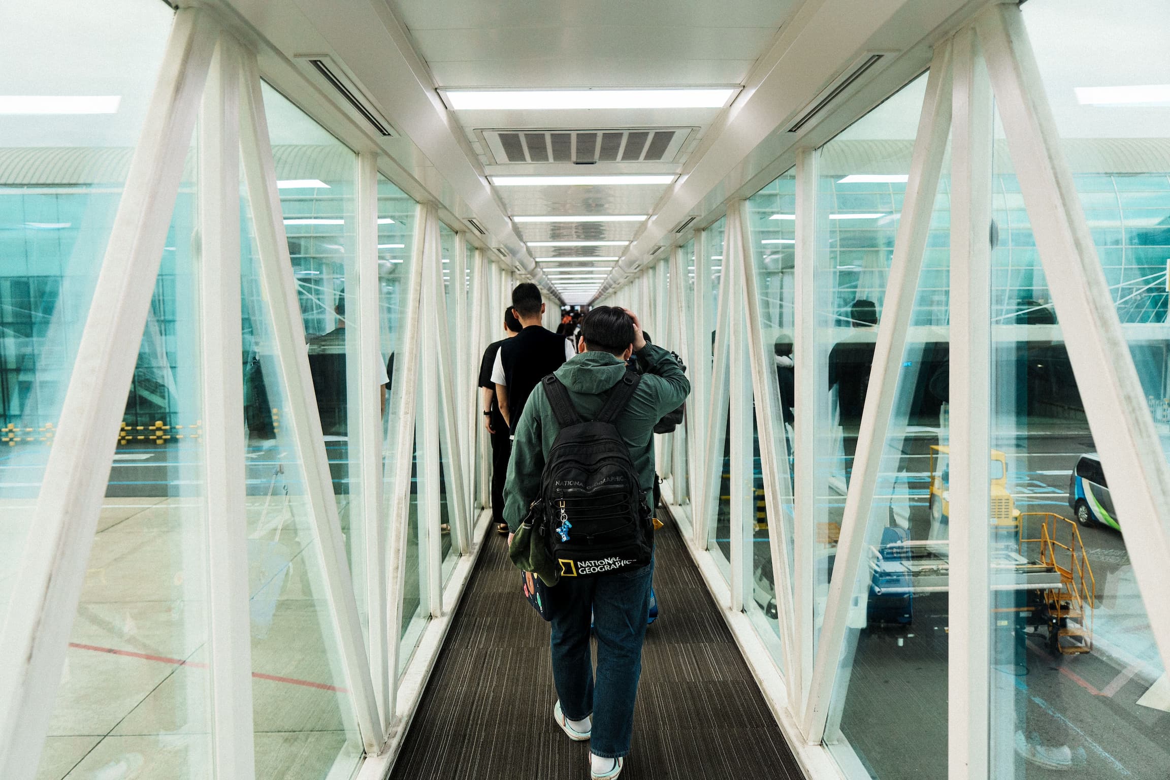 Pasajero con maleta carry-on y mochila de mano en la puerta de embarque del aeropuerto